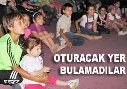 Çocuklar yerlerde oturarak izledi