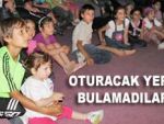 Çocuklar yerlerde oturarak izledi